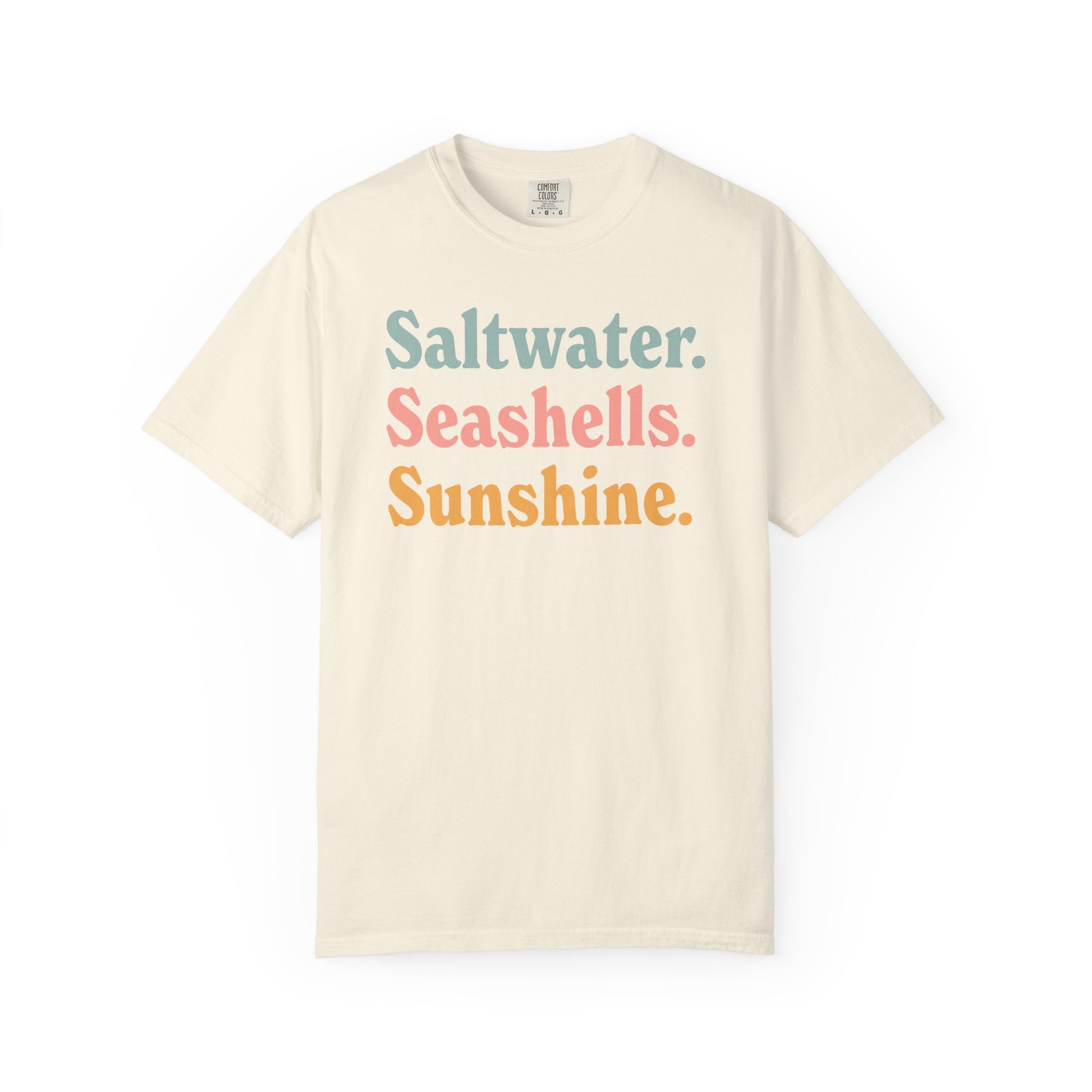 Ivory Comfort Colors t-shirt with colorful text 'Saltwater. Seashells. Sunshine.' on a white background