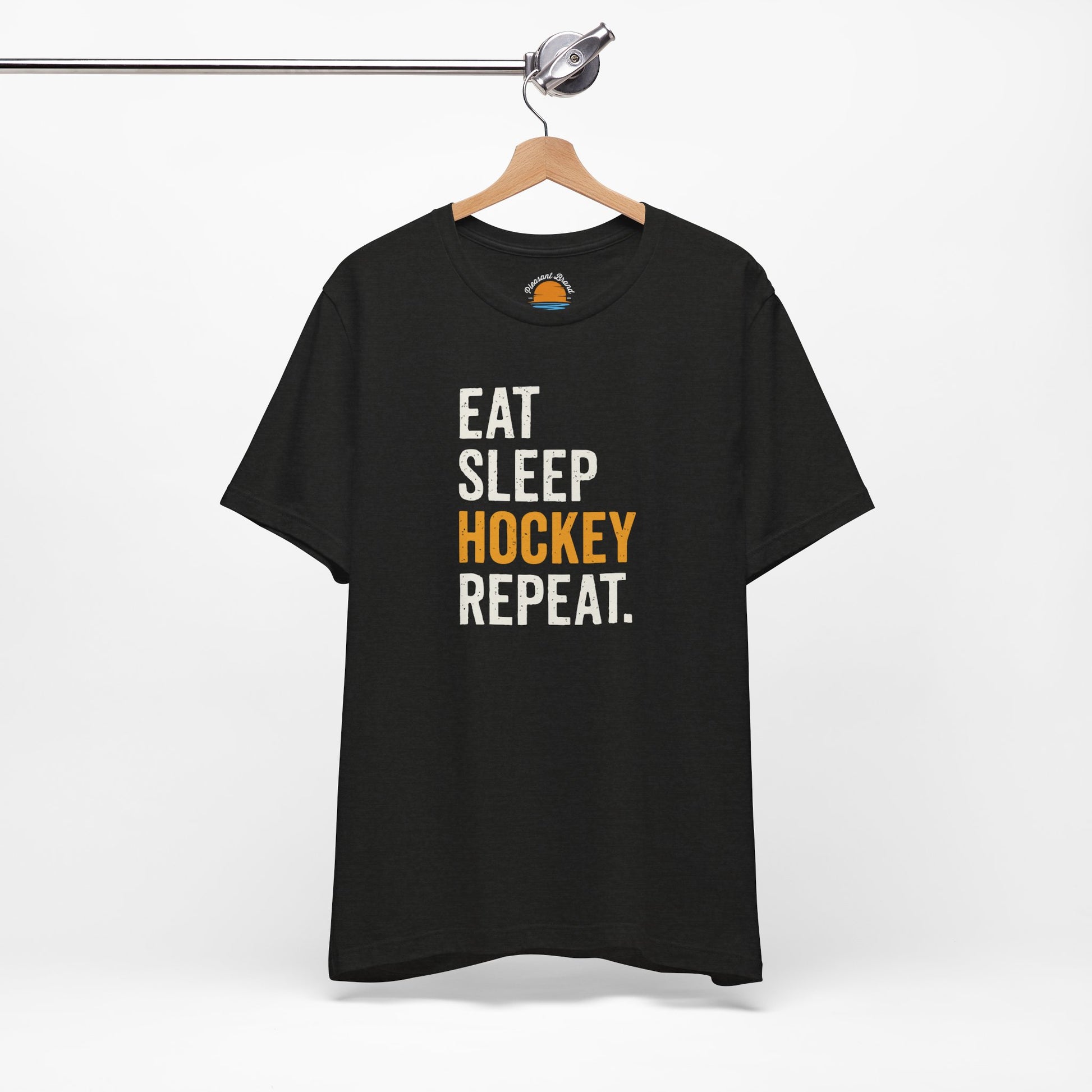 Black heather t-shirt with 'Eat Sleep Hockey Repeat' text on a hanger against a white background