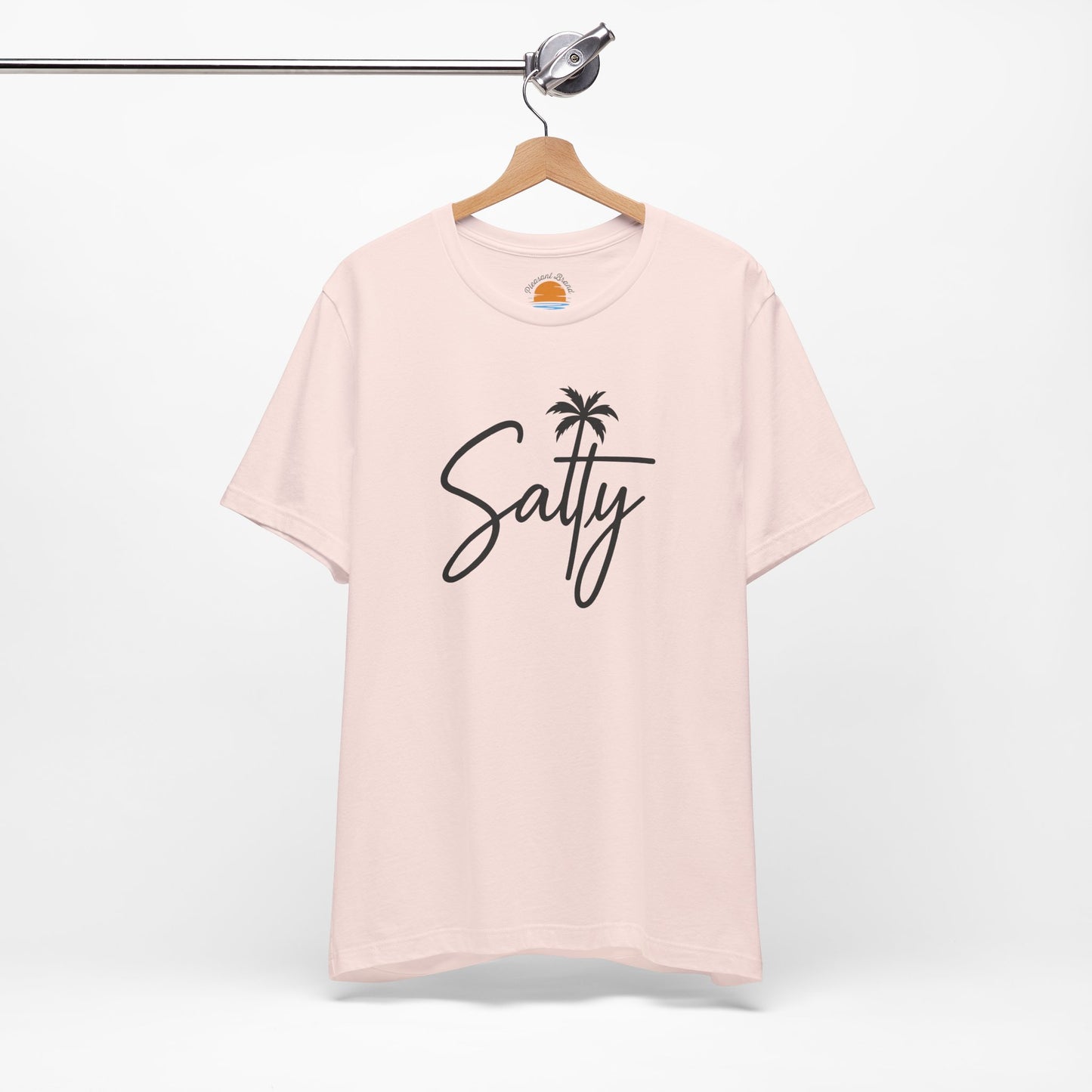 Pink t-shirt with 'Salty' and a palm tree graphic on a hanger against a white background