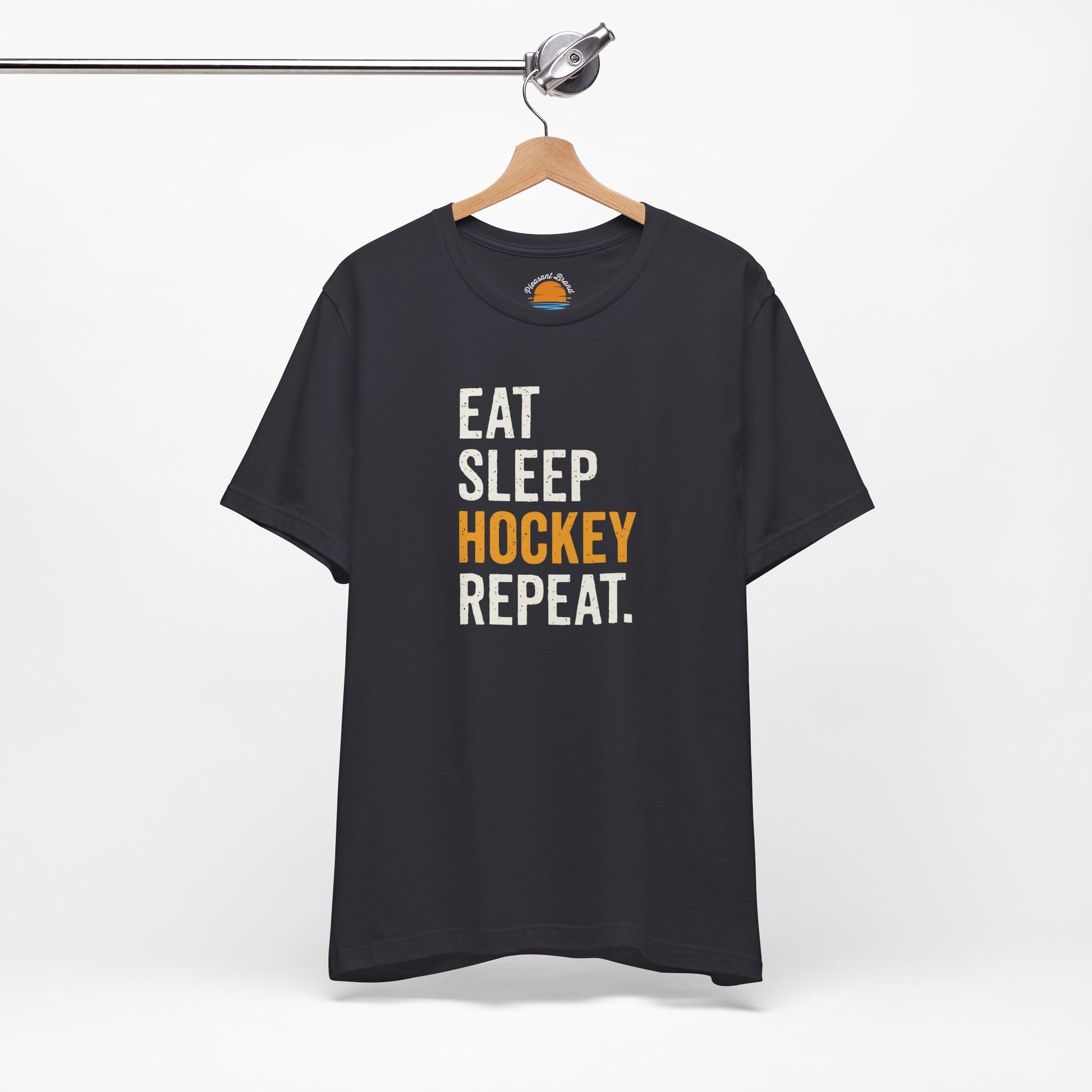 Dark grey t-shirt with 'Eat Sleep Hockey Repeat' text on a hanger against a white background