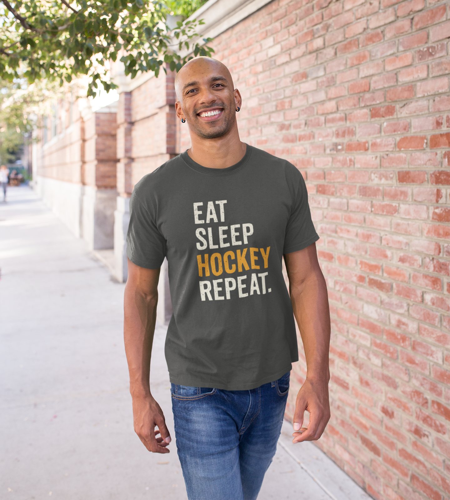 Smiling man in Eat Sleep Hockey Repeat T-Shirt in casual outdoor setting