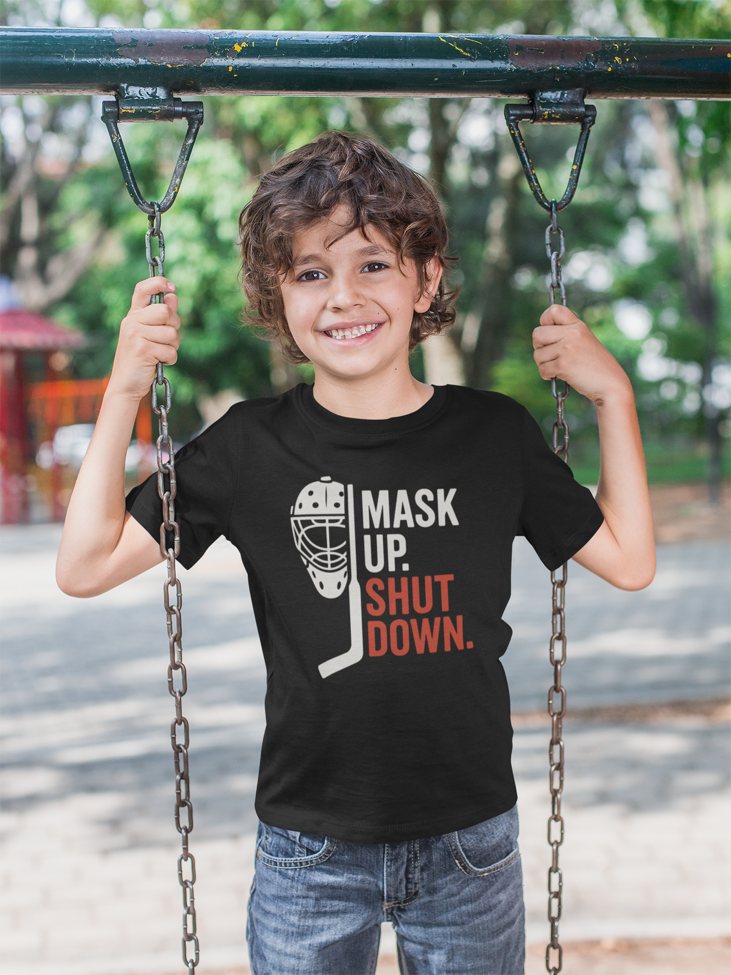 Happy young boy wearing Mask Up Shut Down Youth T-Shirt on playground equipment with big smile