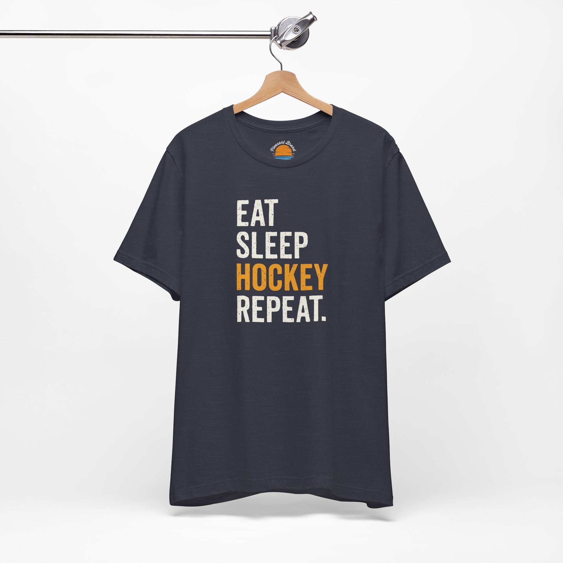 Heather midnight navy t-shirt with 'Eat Sleep Hockey Repeat' text on a hanger against a white background