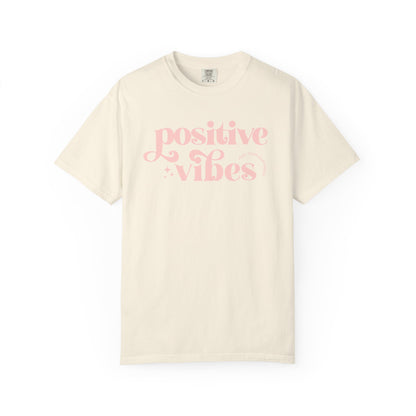 Beige t-shirt with pink 'Positive Vibes' text on a white background