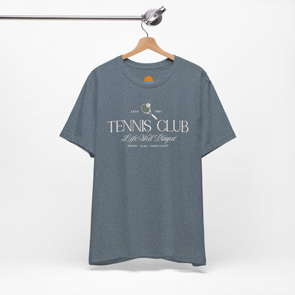 Blue t-shirt with 'Tennis Club' text and graphics on a hanger against a white background