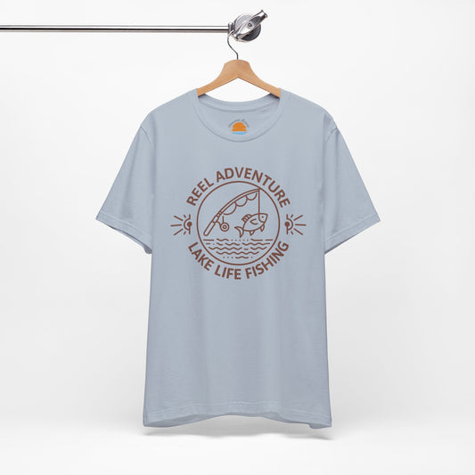 Light blue t-shirt with 'Reel Adventure Lake Life Fishing' graphic on a hanger against a white background