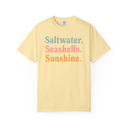 Banana Comfort Colors t-shirt with colorful text 'Saltwater. Seashells. Sunshine.' on a white background