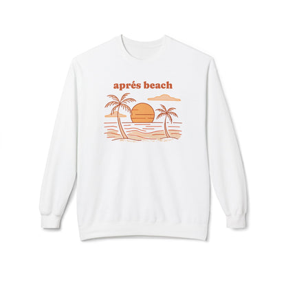 A white crewneck sweatshirt featuring a retro-style beach graphic with two palm trees, a sunset, and the text 'aprés beach' in orange on the chest, displayed against a clean white background.