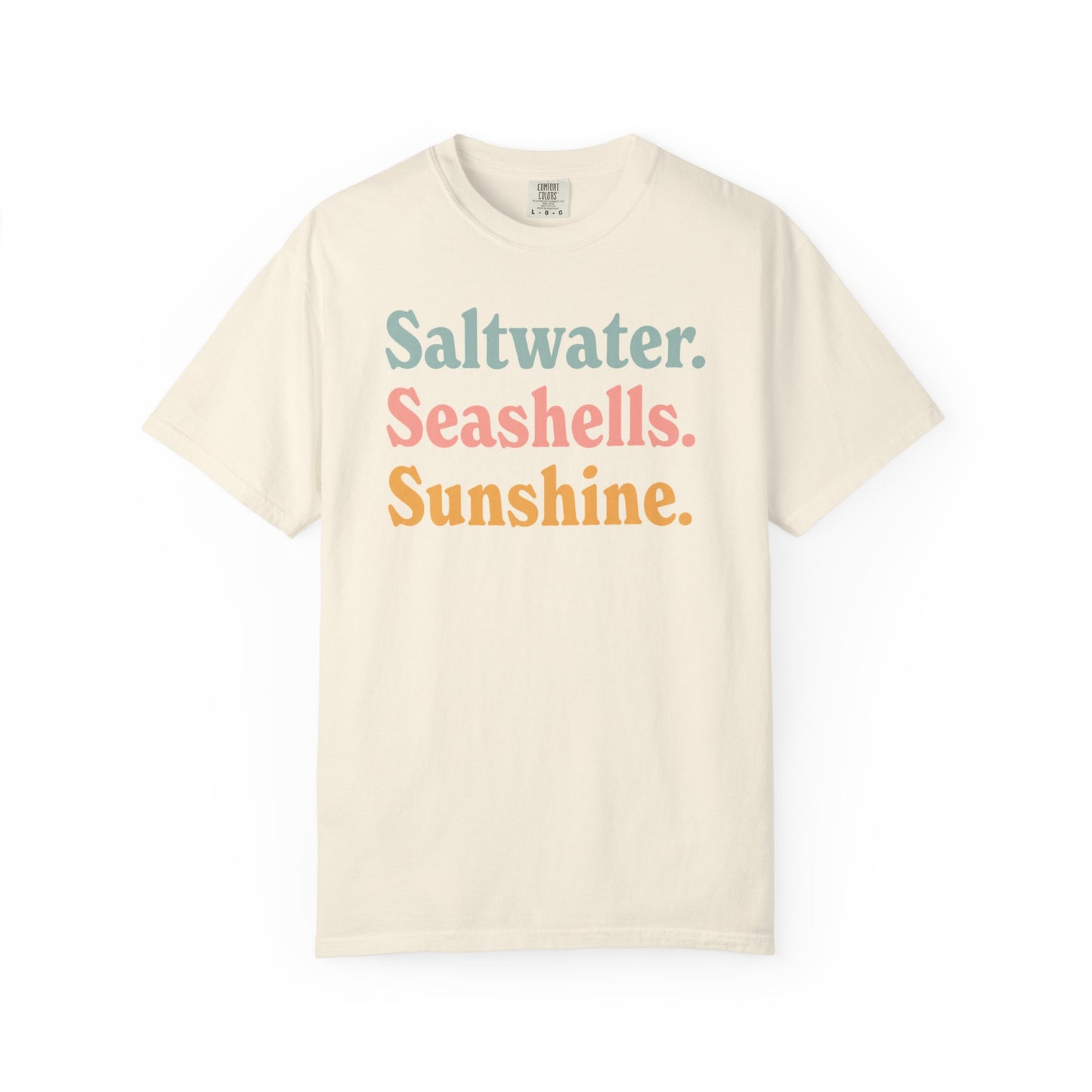Ivory Comfort Colors t-shirt with colorful text 'Saltwater. Seashells. Sunshine.' on a white background