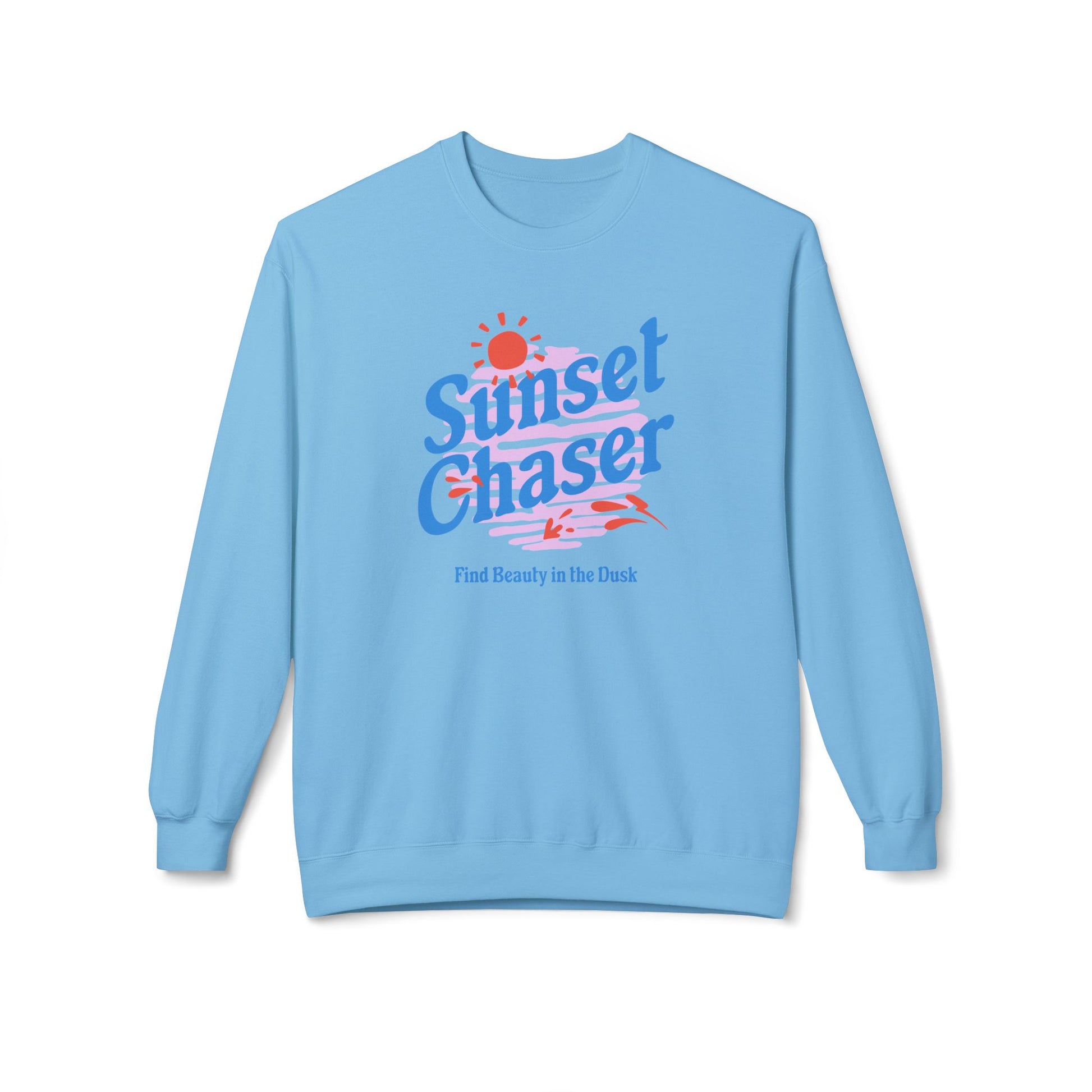 A light blue crewneck sweatshirt featuring a retro-style graphic on the chest with the text 'Sunset Chaser' in blue and red, a small red sun, and the phrase 'Find Beauty in the Dark' underneath, displayed on a clean white background.