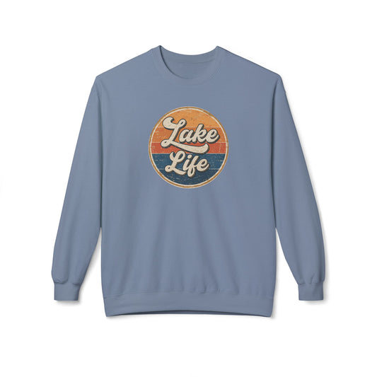 A dusty blue crewneck sweatshirt featuring a circular retro-style graphic on the chest with the words 'Lake Life' in white script over orange and navy blue stripes.