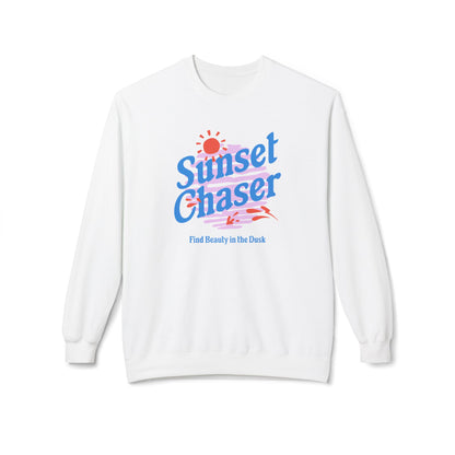A white crewneck sweatshirt featuring a colorful retro-style graphic on the chest with the text 'Sunset Chaser' in blue and pink, a red sun, and the phrase 'Find Beauty in the Dark' in blue below it.