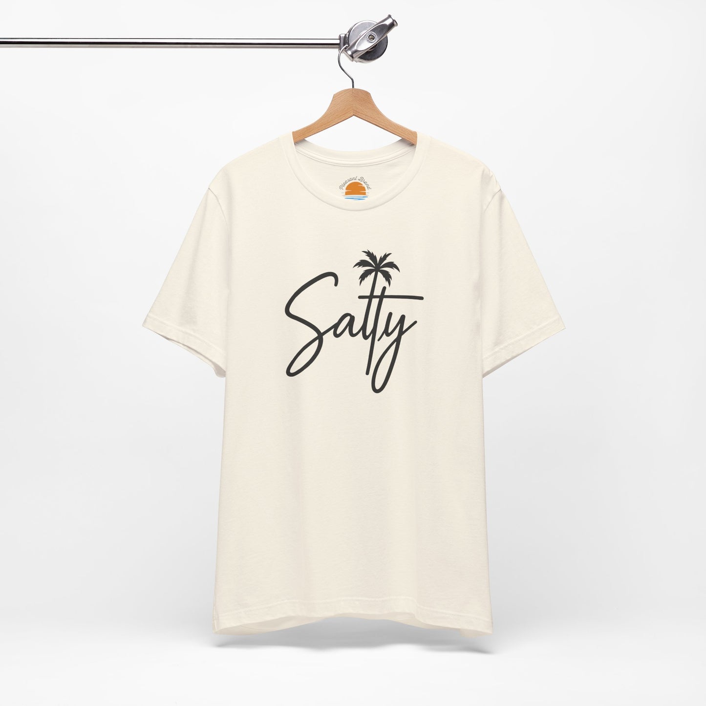 Beige t-shirt with 'Salty' and a palm tree design on a hanger against a white background