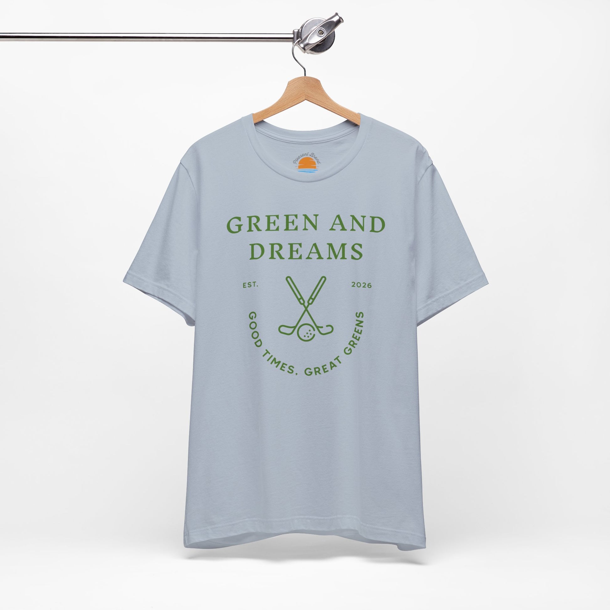 Light blue t-shirt with 'Green and Dreams' graphic design and text on a hanger against a white background