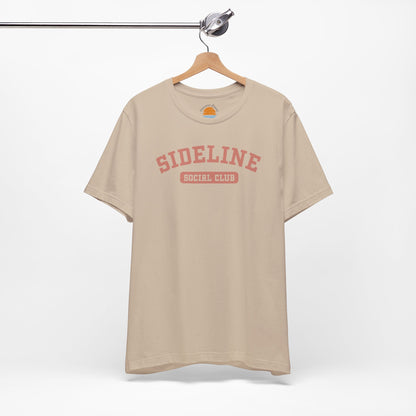 Tan t-shirt with 'Sideline Social Club' text on a hanger against a white background