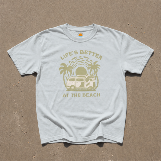 Light blue t-shirt with 'Life's Better at the Beach' graphic on sand