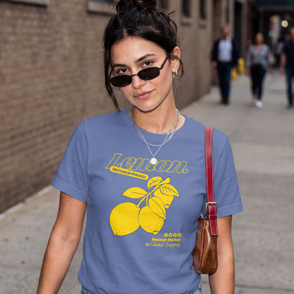 Woman wearing a blue t-shirt with yellow lemon graphic and text on a city street.