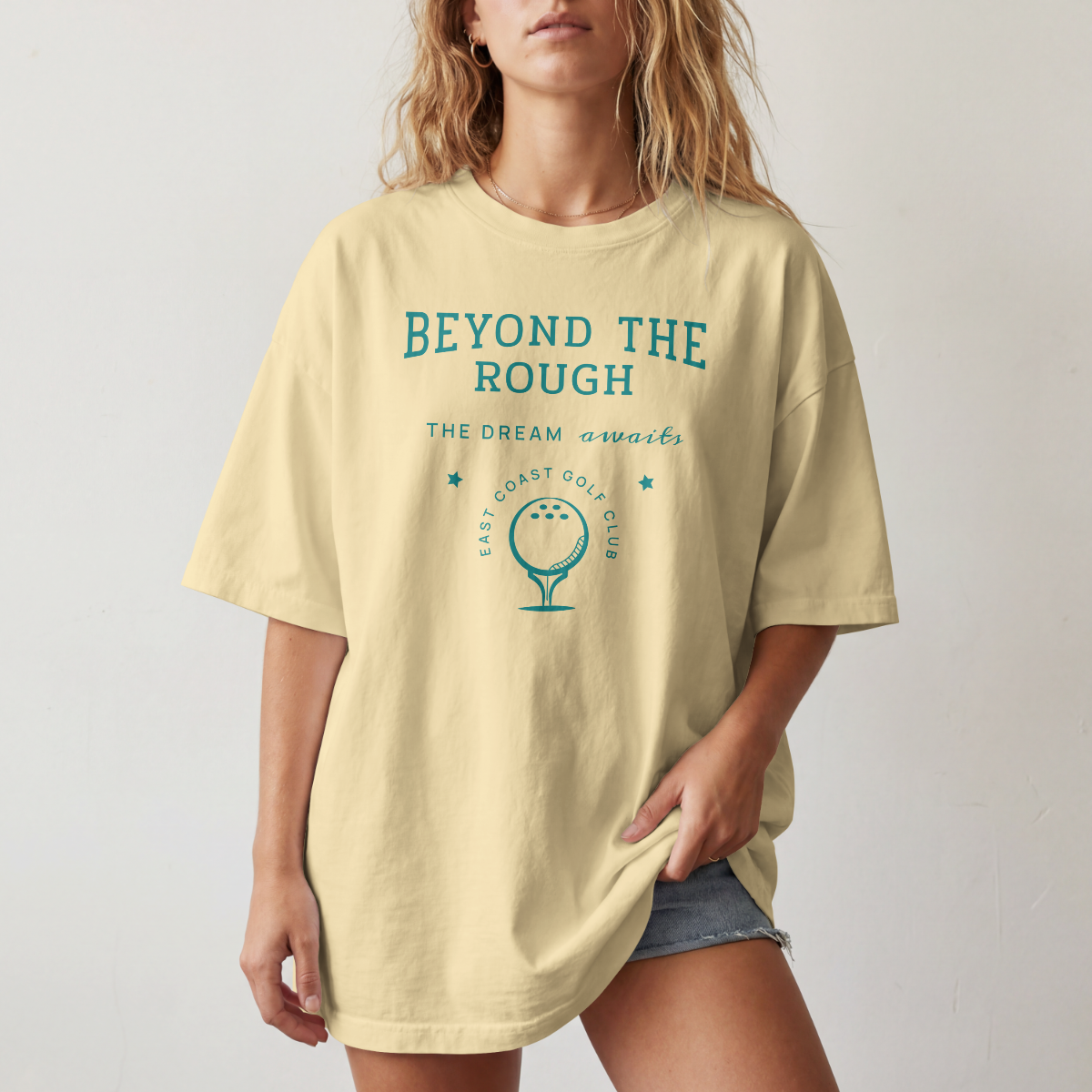 Woman wearing yellow t-shirt with 'Beyond the Rough' text and golf graphic 