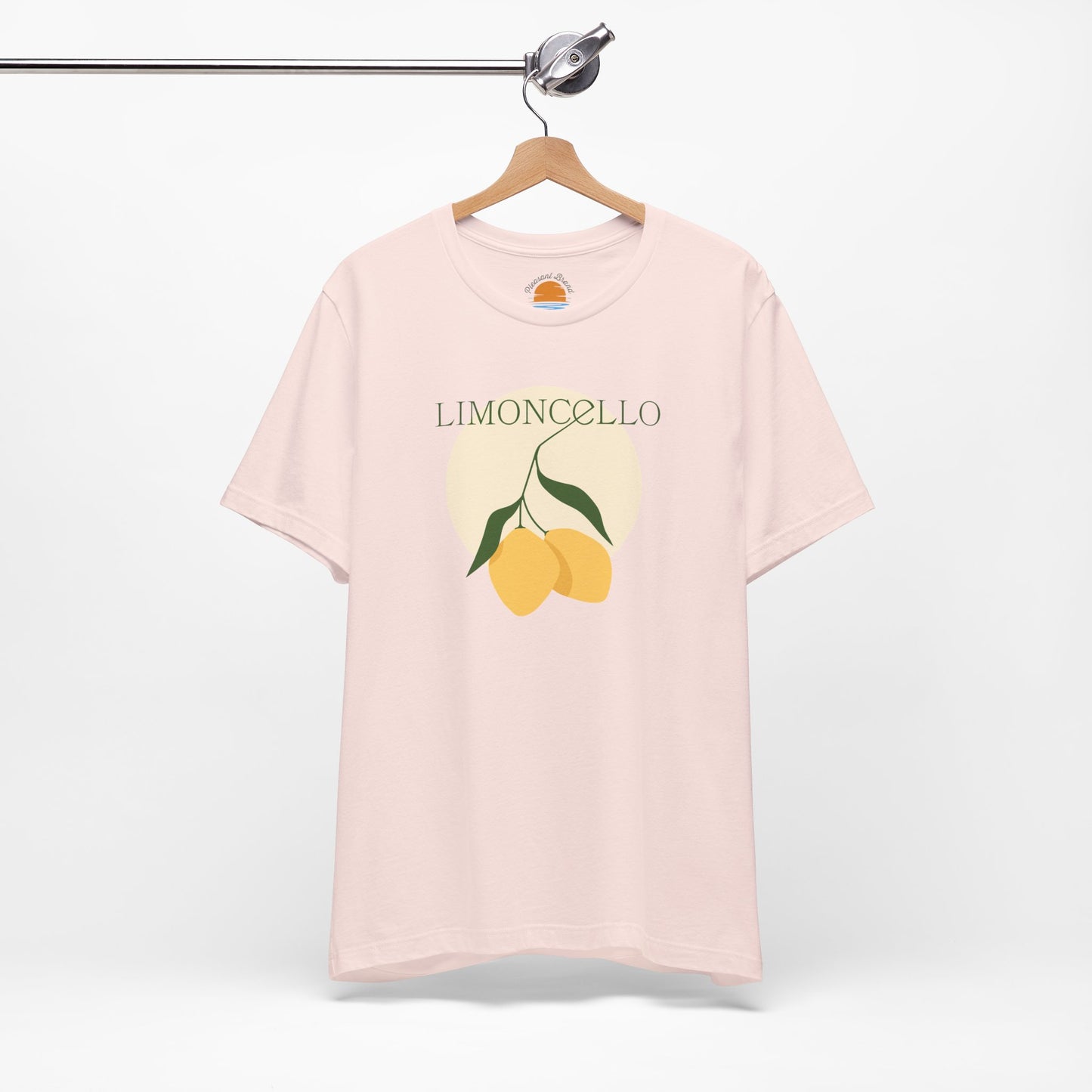 Pink t-shirt with lemon graphic and 'Limoncello' text on a hanger against a white background