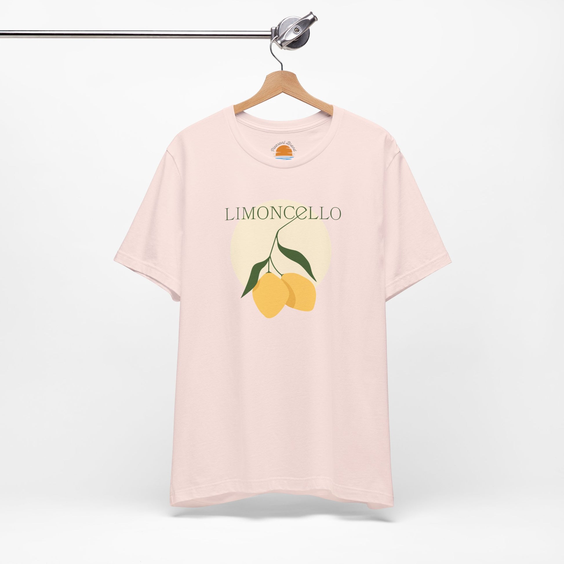 Pink t-shirt with lemon graphic and 'Limoncello' text on a hanger against a white background