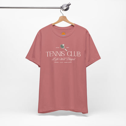 Mauve t-shirt with 'Tennis Club' text and graphics on a hanger against a white background