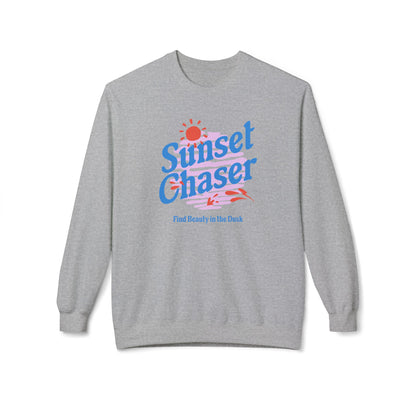 A heather gray crewneck sweatshirt featuring a colorful retro-style graphic on the chest that reads 'Sunset Chaser' with a sun, stripes, and small red/orange shapes, plus the phrase 'Find Beauty in the Duck' underneath.