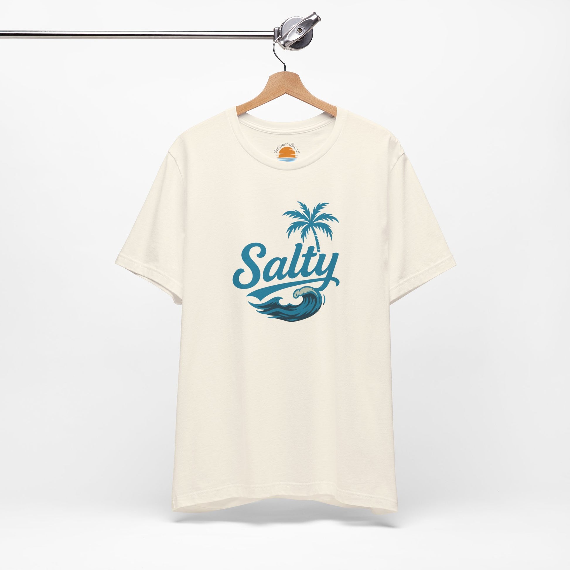 Beige t-shirt with 'Salty' blue wave and palm tree design on a hanger against a white background