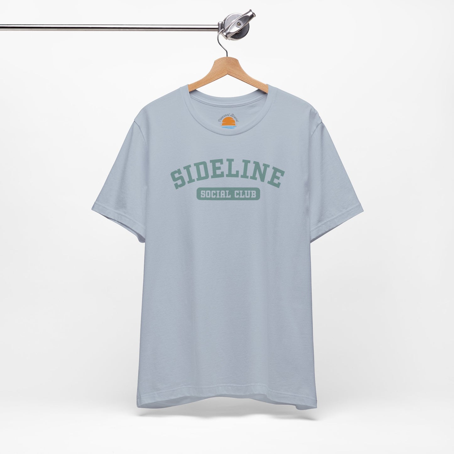 Light blue t-shirt with 'Sideline Social Club' text on a hanger against a white background
