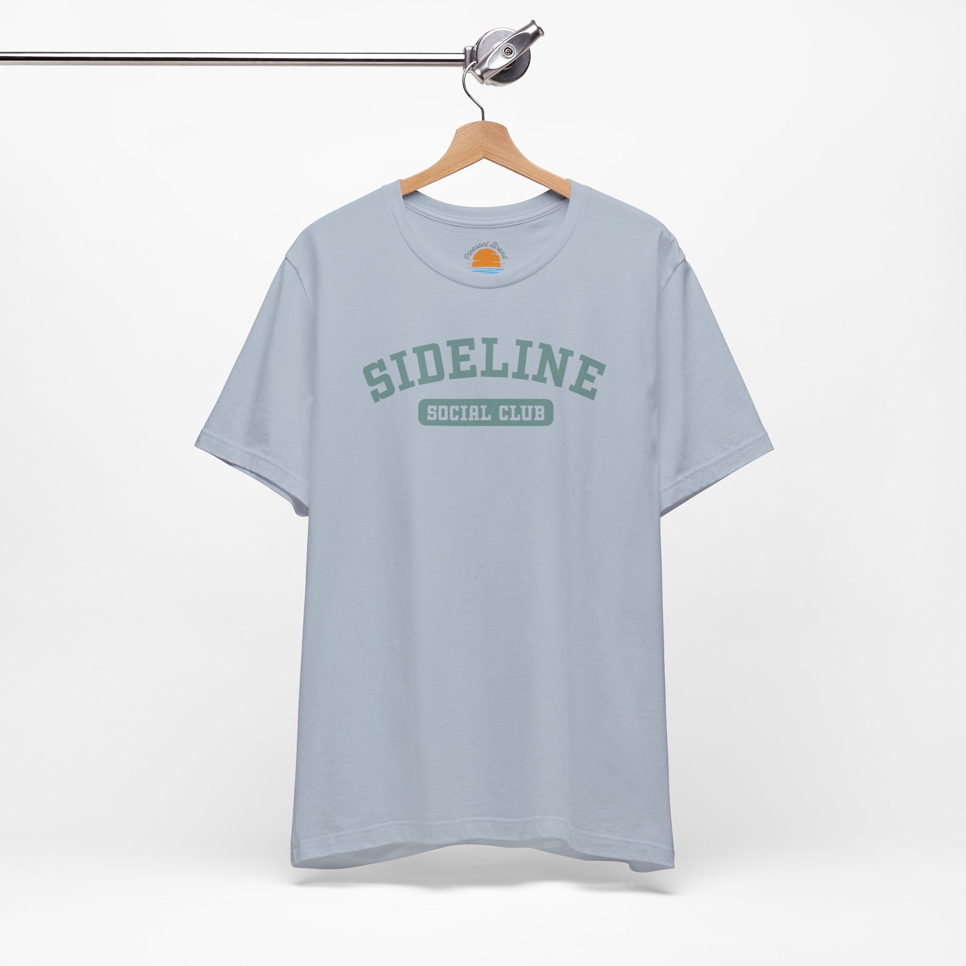Light blue t-shirt with 'Sideline Social Club' text on a hanger against a white background
