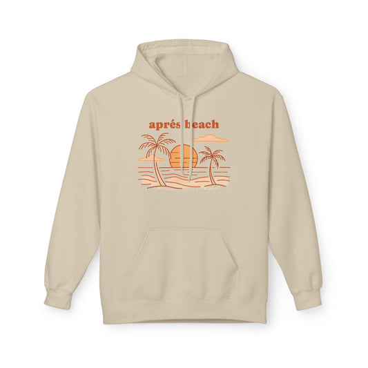A light beige pullover hoodie, featuring a retro-style orange graphic of palm trees, a sun, and waves with the text 'après beach' printed above it.