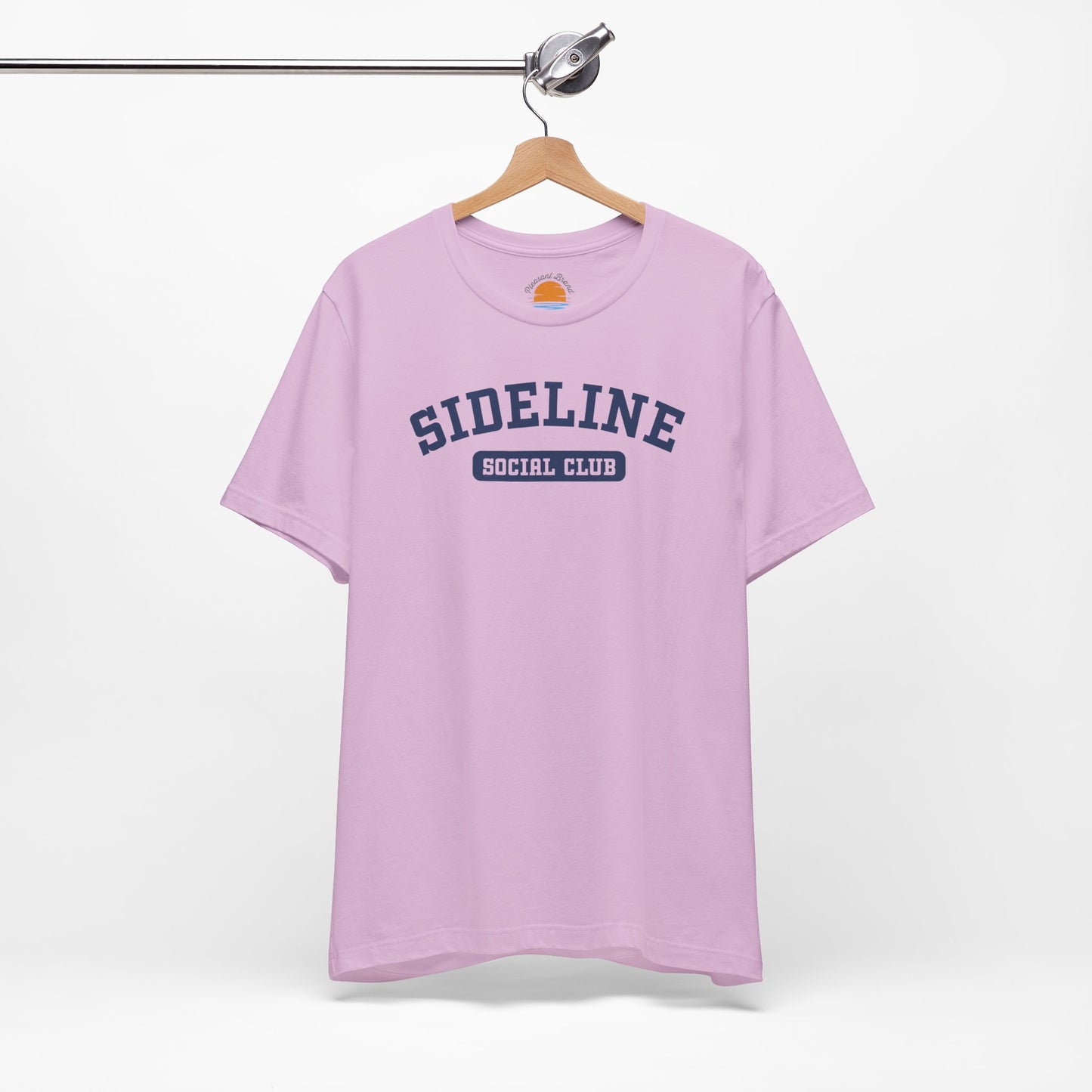 Lilac t-shirt with 'Sideline Social Club' text on a hanger against a white background