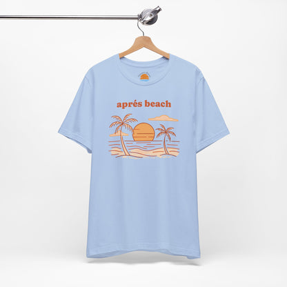 Baby blue color t-shirt with 'après beach' sunset and palm trees graphic design on a hanger against a white background.