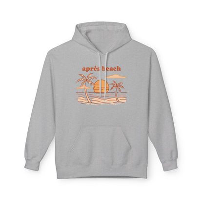 A light gray pullover hoodie with a retro-style beach graphic on the chest. The graphic features the text 'après beach' in orange above a simple illustration of palm trees, a yellow-orange sun, and a sandy beach with blue ocean lines.