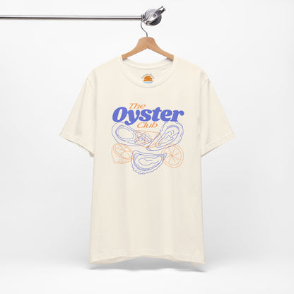 Natural color t-shirt with 'The Oyster Club' graphic on a hanger against a white background
